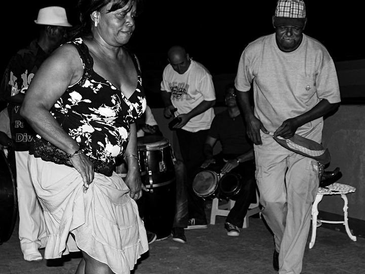 Black and white photo of people dancing to live drums on a Havana rooftop
